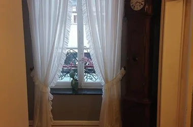 Couloir donnant sur une fenêtre et une horloge comptoise